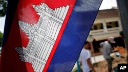 FILE: In this Saturday, July 17, 2010 photo, a Cambodian flag with a depiction of Angkor Wat in the center is hoisted near a construction site in Siem Reap, about 143 miles (230 kilometers) northwest of the capital, Phnom Penh, Cambodia.
