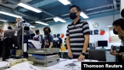 FILE PHOTO: Staff members of Apple Daily work on their final edition in Hong Kong.