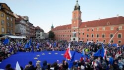 Para pengunjuk rasa tampak mengibarkan bendera Polandia dan Uni Eropa dalam aksi yang dilakukan untuk mendukung keanggotan Polandia di blok tersebut. Aksi tersebut dilakukan di Warsawa pada 10 Oktober 2021. (Foto: AP)