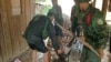 An unidentified injured soldier is helped in a make-shift stretcher by his comrades after a tank he was riding was hit by a rocket Sunday, July 6, 1997, in fighting between Second Premier Hun Sen and Prince Ranarridh's armies, Phnom Penh, Cambodia. 