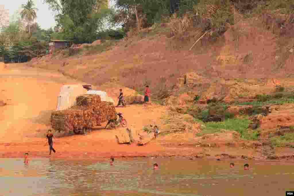 Children swimming near a port in Chhloung district, Kratie province, Cambodia, March 16, 2014. (Nov Povleakhena/VOA Khmer)