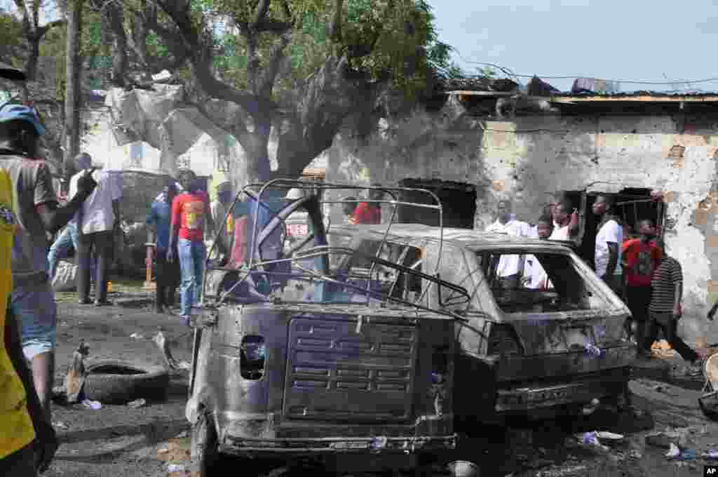 Mutane sun taru kusa da inda bam ya tashi cikin mota a kasuwar &quot;Monday Market&quot; ta Maiduguri, talata 1 Yuli, 2014. Mutane da dama sun mutu, akasarinsu mata tsoffi da almajirai dake bara.