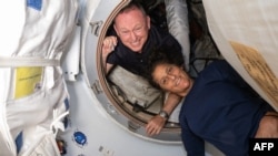 Astronaut Butch Wilmore dan Suni Williams berada di dalam ruang depan di Stasiun Antariksa Internasional (ISS) dalam foto yang dirilis pada 2 Juli 2024. (Foto: Handout/NASA/AFP)