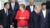 Arhiva - Francuski predsednik Emanuel Makron, levo, razgovara sa nemačkom kancelarkom Angelom Merkel, dok predsednik Donald Tramp zauzima svoje mesto pred grupno fotografisanje u novom sedištu NATO-a u Briselu, 25. maja 2017.