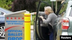 Seorang warga memasukkan surat suaranya untuk pemilihan pendahuluan di sebuah kotak suara (drop box) di Rockville, Maryland, AS, 2 Juni 2020. (REUTERS / Kevin Lamarque).
