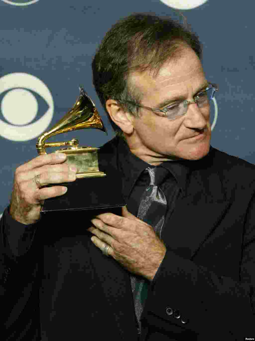 Komedian Robin Williams memegang Grammy Award ketika berpose bagi para fotografer di acara tahunan Grammy Awards ke-45 di Madison Square Garden, at New York, 23 Februari 2003. Williams memenangkan Grammy kategori &quot;Best Spoken Comedy Album&quot; untuk &quot;Robin Williams Live 2002.&quot;