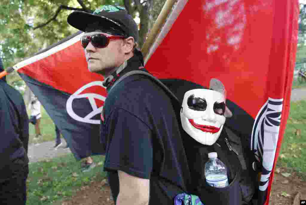 An anti-fascist demonstrator marches on the campus of the University of Virginia during a rally marking the anniversary of last year's Unite the Right rally in Charlottesville, Va., Saturday, Aug. 11, 2018.