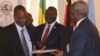 Rebel leader Riek Machar (center) looks on negotiators sign an agreement last November recommitting both sides to ending hostilities.
