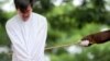 FILE - One of two Indonesian men is publicly caned for having sex, in a first for the Muslim-majority country where there are concerns over mounting hostility towards the small gay community, in Banda Aceh, May 23, 2017.