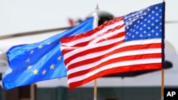 Bendera AS dan Uni Eropa berkibar. (Foto: AP/Jacquelyn Martin)