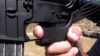 FILE - Shooting instructor Frankie McRae demonstrates the grip on an AR-15 rifle fitted with a bump stock at his 37 PSR Gun Club in Bunnlevel, North Carolina, on Oct. 4, 2017.