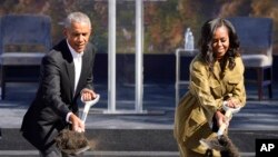 Mantan Presiden AS Barack Obama (kiri) dan sang istri Michelle Obama tampak melemparkan tanah dalam upacara peletakan batu pertama untuk pembangunan Obama Presidential Center di Chicago pada 28 September 2021. (Foto: AP/Charles Rex Arbogas)
