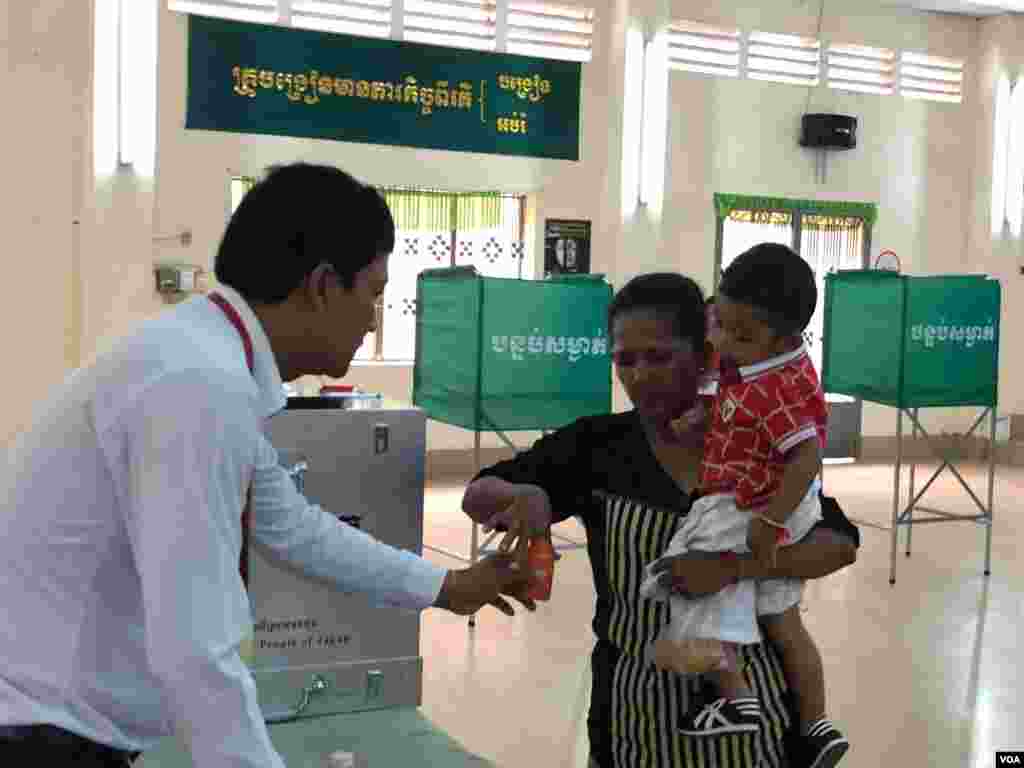 ស្ត្រី​​កម្ពុជា​ម្នាក់​​​បោះឆ្នោត​​​​ជ្រលក់​ម្រាមដៃ​នៅ​ក្រោយ​ការ​បោះឆ្នោត​នៅ​ការិយាល័យ «​សាលា​គរុកោសល្យ​វិ​ក្រិ​ត្យ​ការ​ក្រុង​» សង្កាត់​តាខ្មៅ ក្រុង​តាខ្មៅ​ ខេត្ត​កណ្តាល​ កាល​ពី​ព្រឹក​ថ្ងៃ​អាទិត្យ ទី​២៩ ខែ​កក្កដា ឆ្នាំ២០១៨។ (សុខ ខេមរា/VOA)