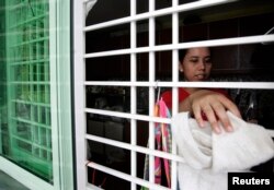 PRT yang berasal dari Indonesia membersihkan rumah majikannya di Kuala Lumpur 26 Juni 2009. (Foto: Reuters)