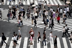 Warga mengenakan masker saat menyebrang jalan di Shibuya, Tokyo, 9 Juli 2020.