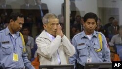 Former Khmer Rouge S-21 prison chief Kaing Guek Eav alias Duch (C) greets the court during his appeal hearing at the Court Room of the Extraordinary Chambers in the Courts of Cambodia (ECCC) on the outskirts of Phnom Penh February 3, 2012.