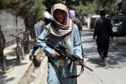 A Taliban fighter stands guard at a checkpoint in the Wazir Akbar Khan neighborhood in the city of Kabul, Afghanistan, Aug. 22, 2021.