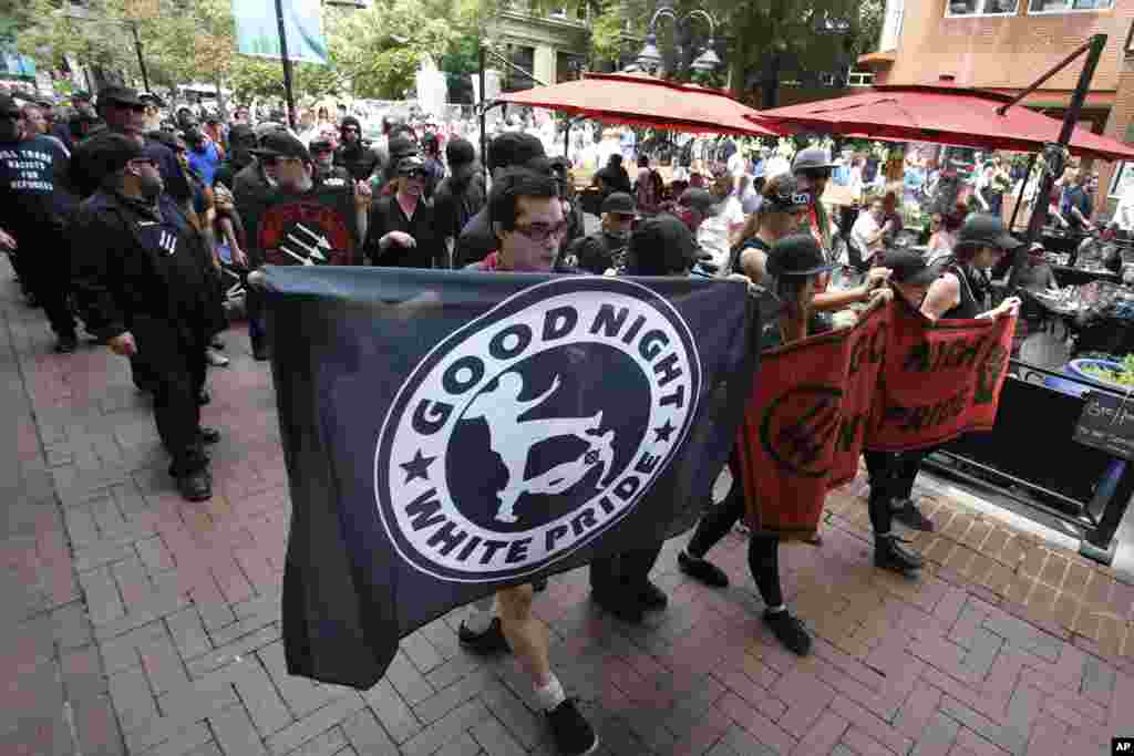 A group anti-fascism demonstrators march in the downtown area in anticipation of the anniversary of last year's Unite the Right rally in Charlottesville, Va., Saturday, Aug. 11, 2018.
