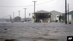 A home damaged by Hurricane Harvey remains surrounded by flood waters, Aug. 26, 2017, in Rockport, Texas. 