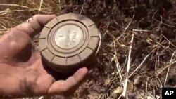 Gambar ranjau darat dari sebuah video yang diambil 7 September 2015 dan dirilis oleh Pusat Pembersihan Ranjau dan Rehabilitasi Suriah, seorang relawan mengambil ranjau darat dari sebuah lahan di Daraa, Suriah. (Foto:Dok)