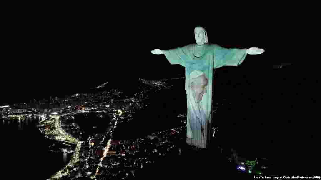 Gambar Paus Fransiskus diproyeksikan pada patung Kristus Sang Penebus di kota Rio de Janeiro, Brazil. (AFP) 