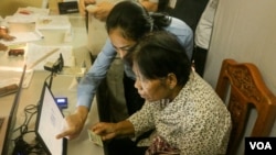 Voter registration official talks to an eligible voter to verify detail information for her to register for the local elections next year, in Phnom Penh, on Thursday, September 1, 2016. (Hean Socheata/VOA Khmer)