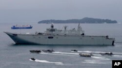 FILE - Royal Australian Navy HMAS Adelaide cruises alongside landing crafts with Philippine Marines and Australian troops as they conduct a joint Humanitarian Aid and Disaster Relief (HADR) exercise off Subic Bay in northwestern Philippines. 