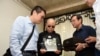 诺贝尔和平奖得主刘晓波的遗孀刘霞（中）在中国辽宁省沈阳举行的刘晓波葬礼期间手捧丈夫刘晓波的遗像。（2017年7月15日）