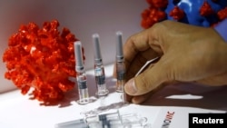 Seorang anggota staf menempatkan kandidat vaksin virus corona dari Sinovac Biotech Ltd di stannya untuk dipajang selama Pameran Internasional China untuk Perdagangan Jasa (CIFTIS) 2020, setelah wabah Covid-19, di Beijing, Cina. (Foto: Reuters)