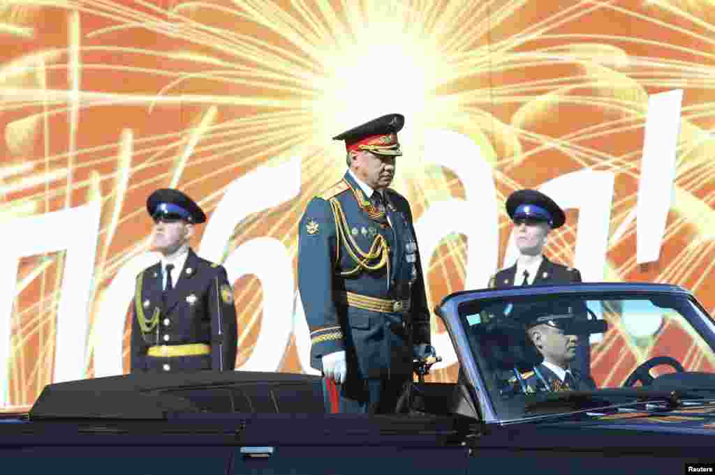 Russian Defence Minister Sergei Shoigu (C) reviews the troops during the Victory Day parade in Moscow's Red Square, May 9, 2014.