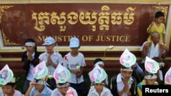 រូបឯកសារ៖ នៅមុខក្រសួងយុត្តិធម៌ កូនៗរបស់ស្ត្រីសកម្មជនបឹងកក់ប្រមូលផ្តុំគ្នាទាមទាររកយុត្តិធម៌ និងការដោះលែងសកម្មជនបឹងកក់១៥នាក់ ដែលត្រូវបានចាប់ខ្លួន កាលពីថ្ងៃទី៣១ ខែឧសភា ឆ្នាំ២០១២។