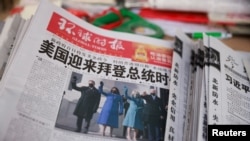 Koran Global Times menampilkan foto pelantikan Presiden AS Joe Biden dan Wakil Presiden AS Kamala Harris di halaman depan, di sebuah kios koran di Beijing, China, Kamis, 21 Januari 2021.
