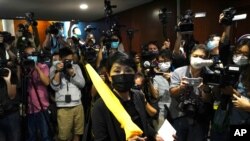 Pro-democracy legislator Mao Mengjing, center, poses for photographers before handing her resignation letters at Legislative Council in Hong Kong, Nov. 12, 2020. 