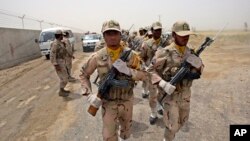 FILE - A group of Iranian border guards march at the eastern border of Iran shared with Pakistan and Afghanistan, near Zabol, Sistan-Baluchistan Province, Iran, July 19, 2011.