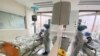 A medical staff is reflected in a mirror as she attends to a COVID-19 patient at a special ward at Arwyp Medical Centre, as South Africa is about the reach a milestone of 1 million infections, in Kempton Park, Dec. 25, 2020.