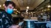 Pekerja restoran Prancis Petit Troit, Joey Tyler, memverifikasi kartu vaksinasi pengunjung yang datang ke restorannya di Los Angeles, California, pada 5 November 2021.
