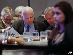 Sen. John McCain, R-Ariz., left, and Sen. Lindsey Graham, R-S.C., right, read the Wall Street Journal newspaper as they wait for President Donald Trump to speak to House and Senate GOP lawmakers at the annual policy retreat in Philadelphia, Jan. 26, 2017.