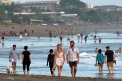Turis berjalan di pantai saat pemerintah memperpanjang PPKM untuk mengekang penyebaran COVID-19 di Badung, Bali, 9 September 2021. (Foto: Antara/Nyoman Hendra Wibowo via REUTERS)