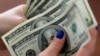 Seorang wanita menghitung uang dolar AS di rumahnya di Buenos Aires, Argentina 28 Agustus 2018. (Foto: Reuters/Marcos Brindicci)