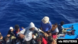 FILE - Migrants in a dinghy are rescued by the Libyan coast guard in the Mediterranean Sea off the coast of Libya, Oct. 18, 2019. 