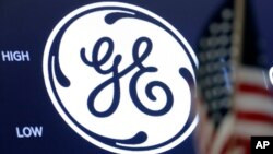 FILE - The General Electric logo appears above a trading post on the floor of the New York Stock Exchange, June 26, 2018. 