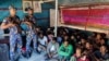 উখিয়ায় রোহিঙ্গা শরণার্থী শিবিরে হামলার পর আটক রোহিঙ্গা শরণার্থীরা নিরাপত্তা কর্মকর্তাদের পাশে বসে আছে। ২৮ অক্টোবর, ২০২২। (এএফপি ছবি/ বাংলাদেশ আর্মড পুলিশ ব্যাটালিয়ন)। ফাইল ছবি।

