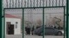 FILE - Residents line up inside the Artux City Vocational Skills Education Training Service Center, which was revealed by leaked documents to be a forced indoctrination camp at the Kunshan Industrial Park in Artux in western China's Xinjiang region, Dec. 3, 2018.