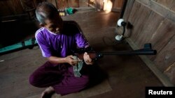 FILE - A man polishes his gun on the outskirts of Bangkok. Experts question how much proposed gun control measures will do to stop gun deaths or drive down one of Asia’s highest firearm ownership rates.