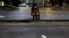 A woman uses a phone near the scene where many people died and were injured in a stampede during a Halloween festival in Seoul, South Korea, Oct. 30, 2022. 