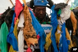 The environmental activist Modou Fall, who many simply call "Plastic Man," wears his uniform before an event about environmental health and pollution management in Dakar, Senegal, Nov. 8, 2022.
