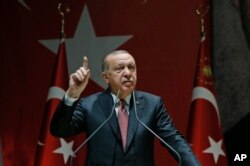 FILE - Turkey's President Recep Tayyip Erdogan talks to members of his ruling Justice and Development Party (AKP), in Ankara, Turkey, Oct. 26, 2018.