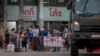 Migrant workers and their families are prepared to be taken to a field hospital for COVID-19 patents in Samut Sakhon, South of Bangkok, Thailand, Monday, Jan. 4, 2021. (AP Photo/Gemunu Amarasinghe)
