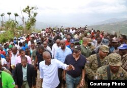 Haitian President Jovenel Moise, in white shirt, and Prime Minister Jack Guy Lafontant, in baseball cap, visited Jérémie, promising houses for people left homeless by a hurricane, March 31, 2017. (B. Magloire / VOA)