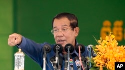 FILE - Cambodia's Prime Minister Hun Sen speaks to garment workers during a visit to a factory outside Phnom Penh, Cambodia, Wednesday, Aug. 30, 2017. Hun Sen is on a country-wide trip visiting the nation's factory workers to hear their hopes and concerns in person. (AP Photo/Heng Sinith)